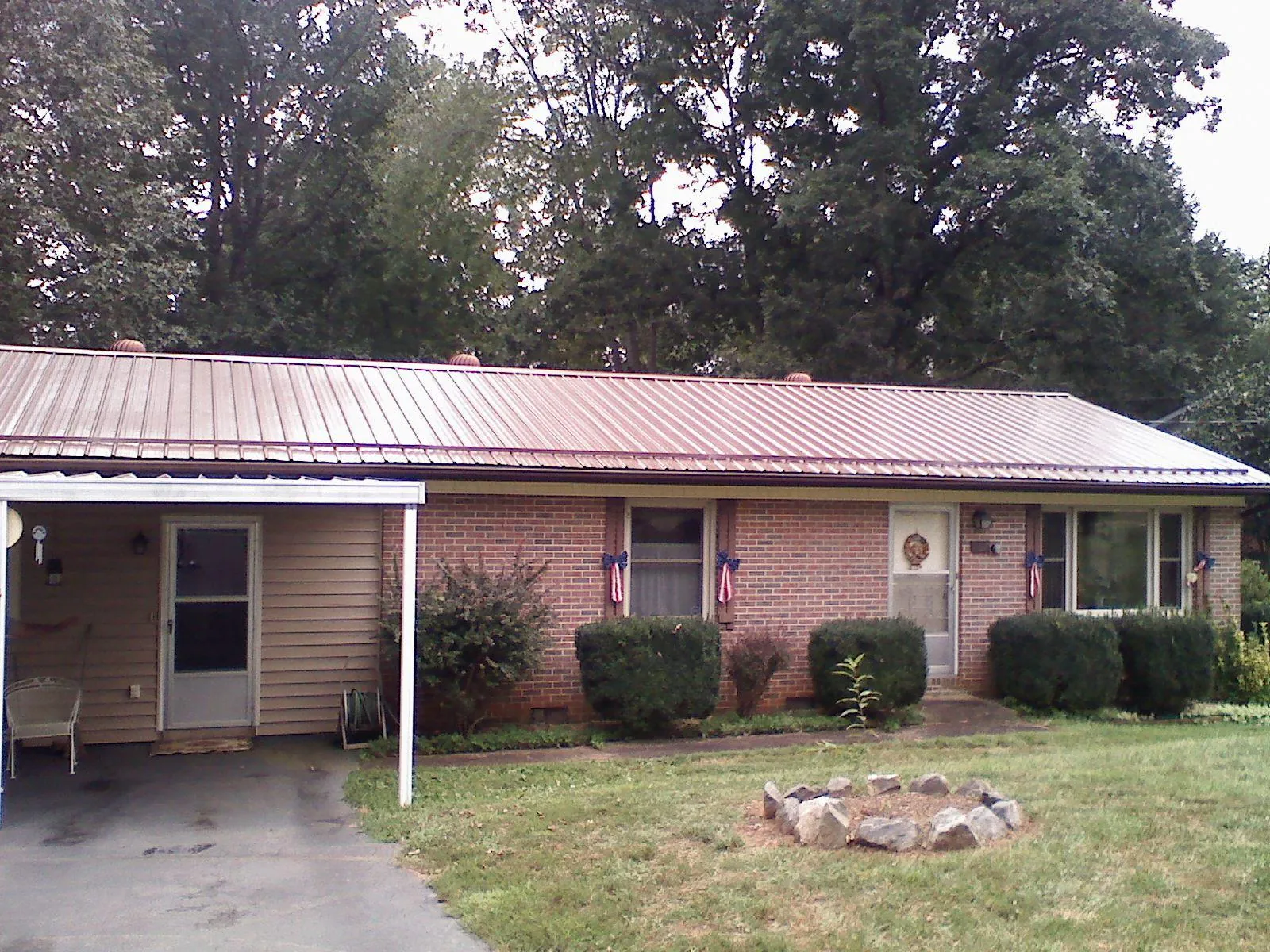 Bronze metal roof and carport on a brick ranch home — Roof Repair work by our crew in Bronson